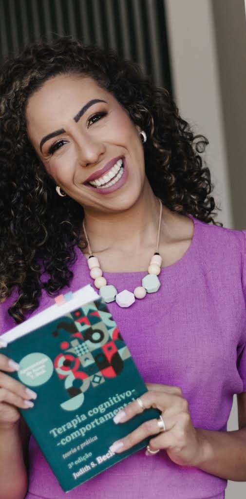 Keri segurando um livro de Terapia Cognitivo-Comportamental