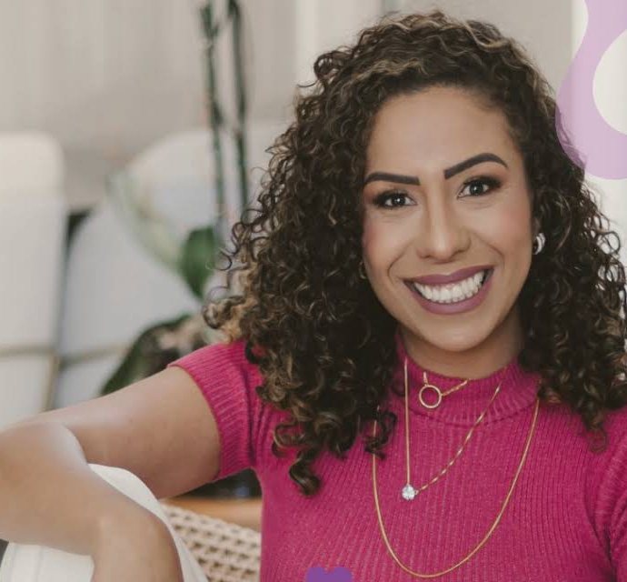 Keri sorrindo, de blusa rosa